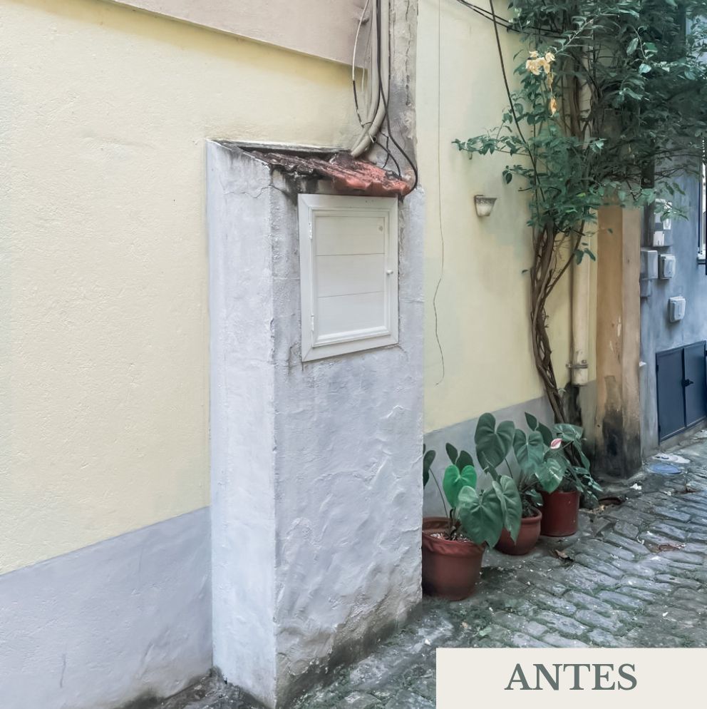 Painel de iluminação externa com fiação exposta, caixa elétrica sem proteção adequada e parede com reboco irregular.